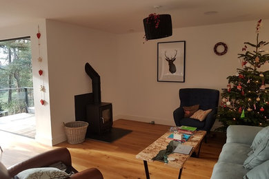 Diseño de sala de estar moderna grande con estufa de leña y marco de chimenea de yeso