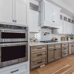 Inspiration för ett stort lantligt vit linjärt vitt skafferi, med en integrerad diskho, släta luckor, bruna skåp, granitbänkskiva, vitt stänkskydd, stänkskydd i keramik, rostfria vitvaror, mellanmörkt trägolv, en köksö och beiget golv