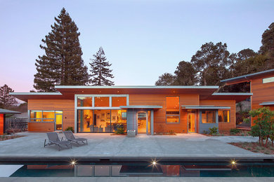 Large modern brown one-story wood house exterior idea in San Francisco with a shed roof and a metal roof