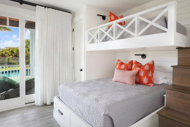 Modelo de dormitorio costero con paredes blancas, suelo de baldosas de porcelana y suelo gris