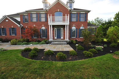 Inspiration for a large timeless red three-story brick exterior home remodel in New York with a hip roof