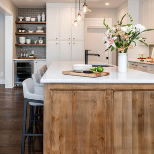 Design ideas for a large transitional l-shaped kitchen pantry in Calgary with a double-bowl sink, raised-panel cabinets, quartz benchtops, grey splashback, stainless steel appliances, medium hardwood floors, with island and subway tile splashback.