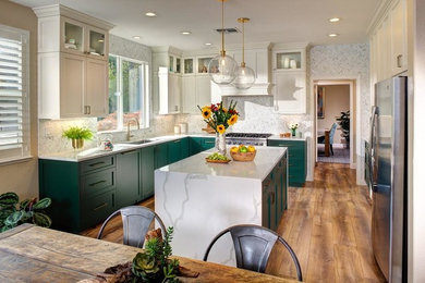 Photo of a mid-sized transitional l-shaped eat-in kitchen in Sacramento with an undermount sink, green cabinets, grey splashback, stainless steel appliances, medium hardwood floors, with island, brown floor, shaker cabinets, quartz benchtops, porcelain splashback and white benchtop.