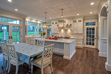 Eat-in kitchen - large traditional u-shaped medium tone wood floor and brown floor eat-in kitchen idea in Philadelphia with a farmhouse sink, beaded inset cabinets, white cabinets, quartz countertops, white backsplash, quartz backsplash, stainless steel appliances, an island and white countertops