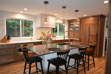 Kitchen - mid-sized modern laminate floor and brown floor kitchen idea in Seattle with an undermount sink, brown cabinets, white backsplash, ceramic backsplash and white countertops