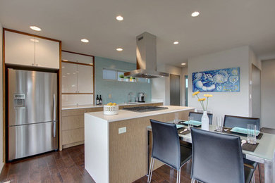 Mid-sized contemporary eat-in kitchen in Seattle with an undermount sink, flat-panel cabinets, light wood cabinets, blue splashback, glass tile splashback, stainless steel appliances, dark hardwood floors and with island.
