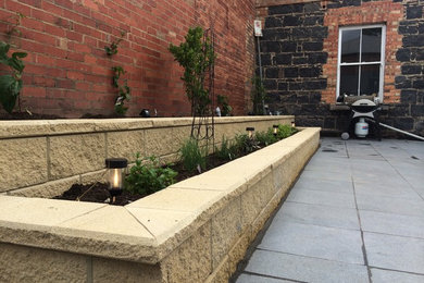 This is an example of a modern patio in Melbourne with natural stone pavers.