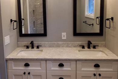 Inspiration for a mid-sized transitional master gray tile and marble tile porcelain tile, gray floor, double-sink and vaulted ceiling shower bench remodel in New York with shaker cabinets, white cabinets, a two-piece toilet, gray walls, an undermount sink, quartz countertops, white countertops and a built-in vanity