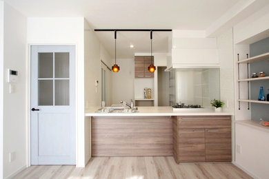 Imagen de cocina lineal moderna de tamaño medio abierta con suelo de madera clara, suelo beige, papel pintado, puertas de armario de madera en tonos medios y encimera de acrílico