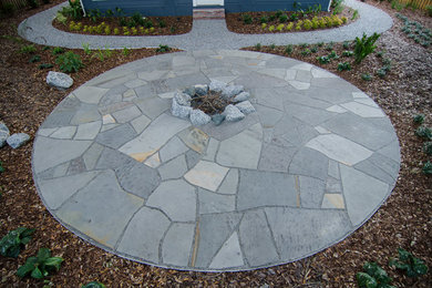 Inspiration for a large rustic backyard stone patio remodel in Tampa with a fire pit