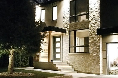 Example of a large minimalist multicolored two-story mixed siding house exterior design in Toronto with a shed roof and a mixed material roof