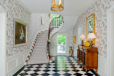 This is an example of a traditional foyer in Baltimore with white walls, a single front door, a glass front door, marble floors and multi-coloured floor.
