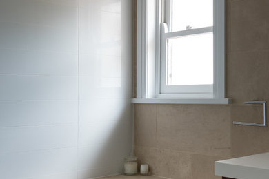 Design ideas for a large modern master bathroom in Canberra - Queanbeyan with flat-panel cabinets, dark wood cabinets, a drop-in tub, an open shower, a one-piece toilet, beige tile, ceramic tile, brown walls, limestone floors, an integrated sink, solid surface benchtops, brown floor and an open shower.
