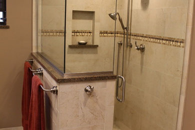 Trendy beige floor corner shower photo in Orlando with brown walls, a hinged shower door, a bidet, raised-panel cabinets, dark wood cabinets, an undermount sink and granite countertops