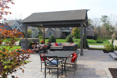Inspiration for a large modern backyard patio in Indianapolis with a fire feature, brick pavers and a gazebo/cabana.