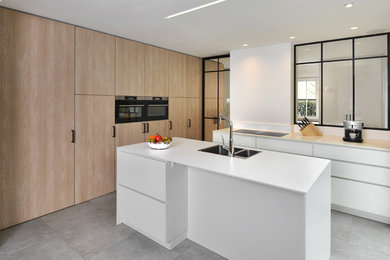 Design ideas for a contemporary kitchen in Other with a double-bowl sink, flat-panel cabinets, white cabinets, window splashback, black appliances, with island, grey floor and white benchtop.