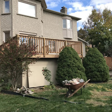 Side view of a raised two-level pressure-treated deck with skirting in Markham