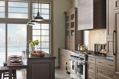 Example of a large transitional galley slate floor enclosed kitchen design in Other with an undermount sink, shaker cabinets, brown cabinets, quartz countertops, beige backsplash, mosaic tile backsplash, stainless steel appliances and an island