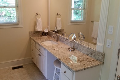 Mid-sized elegant master ceramic tile and beige floor bathroom photo in Little Rock with raised-panel cabinets, white cabinets, beige walls, an undermount sink and granite countertops