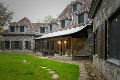 Inspiration for a timeless gray three-story stone exterior home remodel in Montreal with a hip roof