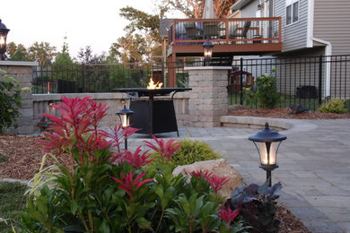 Inspiration for a mid-sized traditional backyard partial sun garden for summer in St Louis with brick pavers.