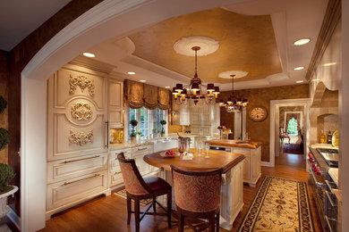 Kitchen - medium tone wood floor kitchen idea in Other with a farmhouse sink, raised-panel cabinets, wood countertops, mosaic tile backsplash, paneled appliances, two islands and white cabinets