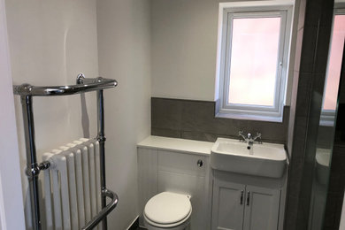 Design ideas for a medium sized contemporary grey and white bathroom in Other with shaker cabinets, white cabinets, a walk-in shower, a one-piece toilet, grey tiles, ceramic tiles, grey walls, ceramic flooring, a built-in sink, wooden worktops, grey floors, an open shower, white worktops, a single sink and a built in vanity unit.