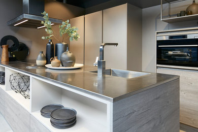 Inspiration for a large industrial single-wall open plan kitchen in Other with an integrated sink, light wood cabinets, with island, brown benchtop, ceramic floors and beige floor.