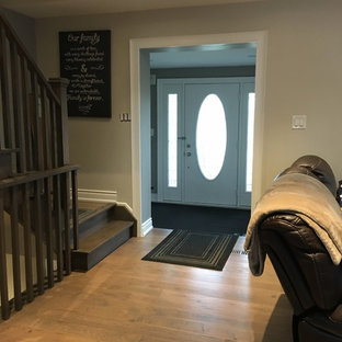 Exempel på en mellanstor eklektisk foajé, med grå väggar, ljust trägolv, en enkeldörr, en vit dörr och beiget golv