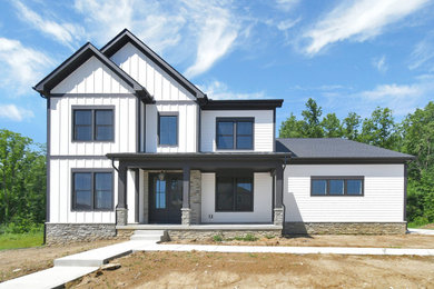 Example of a transitional white two-story concrete fiberboard and board and batten house exterior design in Columbus with a shingle roof and a black roof