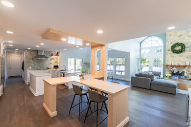 Open concept kitchen - large medium tone wood floor and brown floor open concept kitchen idea in Philadelphia with an undermount sink, shaker cabinets, white cabinets, quartz countertops, green backsplash, ceramic backsplash, stainless steel appliances, two islands and white countertops