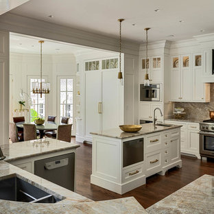 Aménagement d'une grande arrière-cuisine classique en U avec un placard avec porte à panneau encastré, des portes de placard beiges, 2 îlots, un évier encastré, un plan de travail en granite, une crédence multicolore, une crédence en dalle de pierre, un électroménager en acier inoxydable, un sol en bois foncé, un sol marron et un plan de travail multicolore.