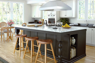 Example of a mid-sized transitional l-shaped light wood floor eat-in kitchen design in Denver with an undermount sink, shaker cabinets, white cabinets, quartzite countertops, stainless steel appliances and an island