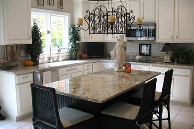 Eat-in kitchen - mid-sized transitional l-shaped ceramic tile eat-in kitchen idea in Baltimore with an undermount sink, recessed-panel cabinets, white cabinets, granite countertops, gray backsplash, stone tile backsplash, stainless steel appliances and an island