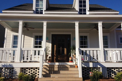 Small classic concrete front porch idea in Raleigh with a roof extension