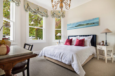 Photo of a traditional bedroom in Auckland with beige walls, carpet and no fireplace.