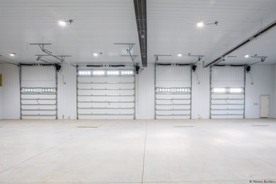 Inspiration for a huge industrial attached four-car garage workshop remodel in Chicago