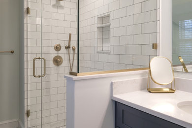 Alcove shower - small modern master white tile and ceramic tile cement tile floor, multicolored floor and double-sink alcove shower idea in Baltimore with shaker cabinets, blue cabinets, a one-piece toilet, white walls, an undermount sink, quartz countertops, a hinged shower door, white countertops and a built-in vanity