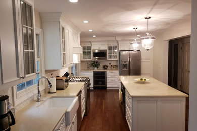 Eat-in kitchen - large contemporary brown floor eat-in kitchen idea in New York with shaker cabinets, white cabinets, quartzite countertops, white backsplash, an island and beige countertops