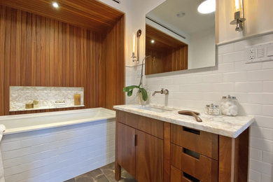 Inspiration for a mid-sized contemporary master white tile and ceramic tile porcelain tile, brown floor, single-sink and wainscoting walk-in shower remodel in Boston with flat-panel cabinets, dark wood cabinets, an undermount tub, a bidet, white walls, an undermount sink, marble countertops, a hinged shower door and a freestanding vanity