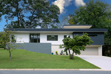 Trendy multicolored split-level stucco and board and batten exterior home photo in Charlotte with a green roof and a white roof