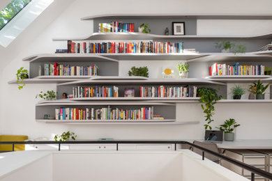 Inspiration for a modern built-in desk light wood floor and vaulted ceiling home office library remodel in Toronto with white walls