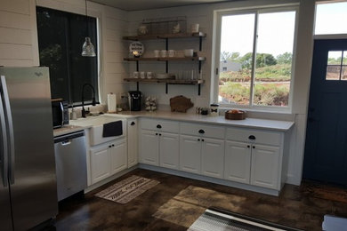 Mid-sized country l-shaped concrete floor and brown floor enclosed kitchen photo in Oklahoma City with a farmhouse sink, shaker cabinets, white cabinets, quartz countertops, an island, white backsplash, wood backsplash and stainless steel appliances