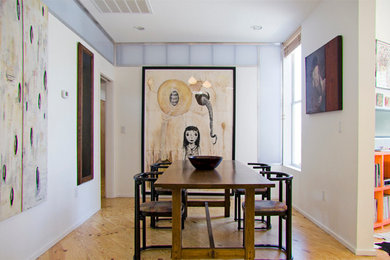 Photo of a small contemporary open plan dining in Austin with white walls and plywood floors.