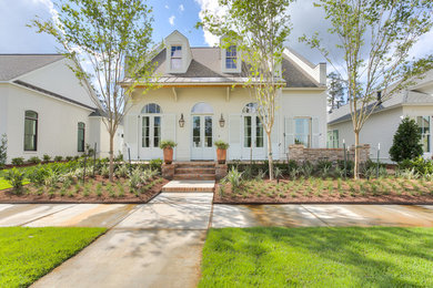 Mid-sized transitional beige two-story vinyl exterior home photo in New Orleans with a mixed material roof