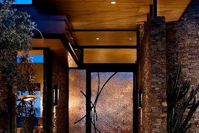 Large minimalist travertine floor entryway photo in Denver with a glass front door