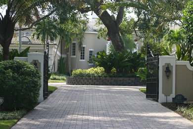 Inspiration for a large tropical front yard partial sun driveway for summer in Miami with brick pavers.