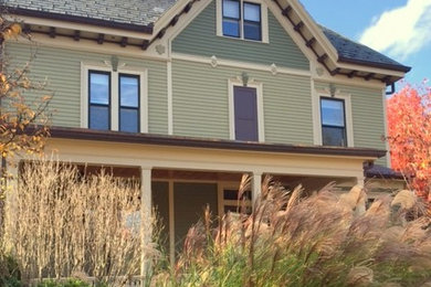 Large ornate green two-story wood exterior home photo in Boston