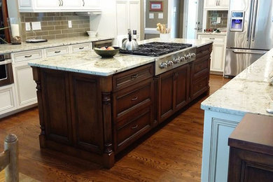 Inspiration for a large timeless u-shaped medium tone wood floor eat-in kitchen remodel in Charlotte with white cabinets, granite countertops, beige backsplash, subway tile backsplash, stainless steel appliances and an island