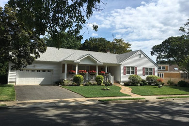 Mid-sized elegant white one-story vinyl exterior home photo in New York with a shingle roof